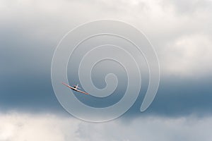 Airplane banking in cloudy sky with dramatic background