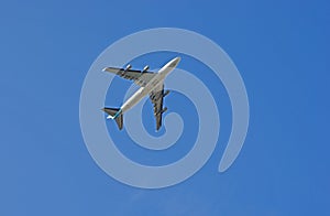 Airplane from below. Airplane against blue sky.