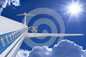 Airplane in blue cloudy sky. White passenger jet fly among clouds. Travel by air transport