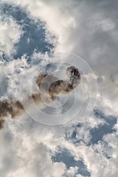 Airplane on a cloudy white sky doing a stunt