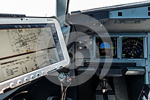 Airplane Cockpit, Captain site with the Primary Flight Display and navigation display in front and the computer with navigational
