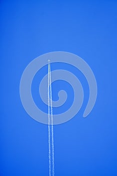 An airplane contrail in a clear blue sky.