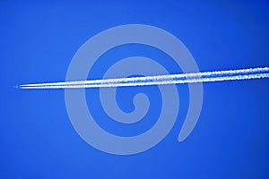 An airplane contrail in a clear blue sky.