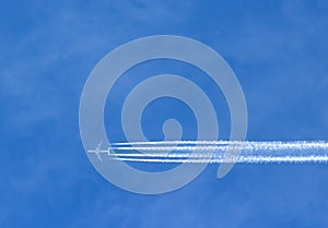 Airplane with contrails in clear blue sky, Cruising altitude