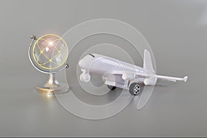 Airplane and crystal globe on grey background. Travel concept. Booking service or travel agency sign. Air transportation