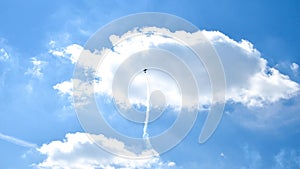 Airplane doing acrobatics in blue sky leaves a smoke. Blue sky with airport contrail clouds