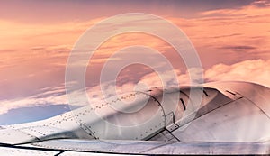 airplane engine over sunset clouds view from airplane window. Filtered image photo