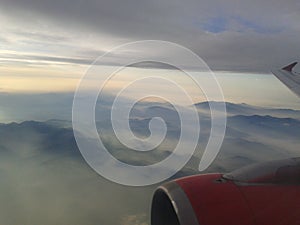 Airplane engine wing with stunning mountains and sky background