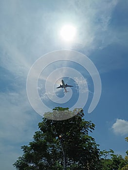 An airplane flies in the bright blue sky, the sunlight splits and looks so amazing photo