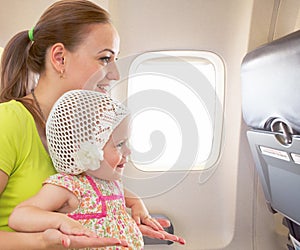 Airplane flight from inside. Woman and kid travelling together.