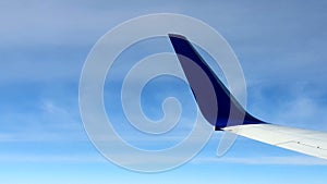 Airplane flight. The wing of the aircraft against the blue sky and white clouds. Background