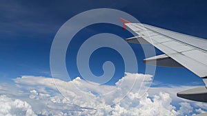 Airplane flight. wing of an airplane flying above the white clouds and blue sky. beautiful aerial view from the window