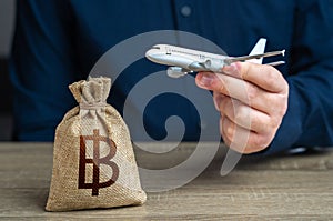 Airplane flights and thai baht money bag. Airline industry income. Budget allocations. Investments in the development of the air