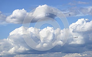 Airplane fly through Blue sky and white Cumulus cloud.