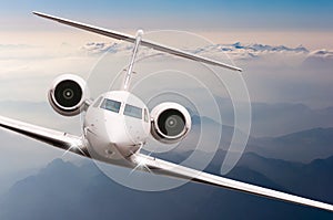 Airplane fly over clouds and Alps mountain on sunset. Front view of a big passenger or cargo aircraft, business jet