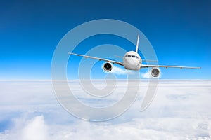 Airplane fly over the clouds and the earth`s surface under the blue sky