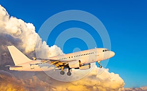 Airplane at fly on the sky with clouds sunset