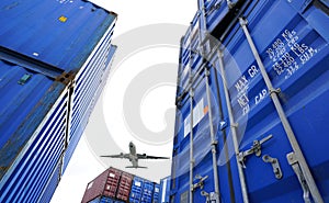 Airplane flying above container logistic. Cargo and shipping business. Container ship for import and export logistic. Logistic