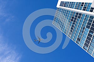 Airplane flying above a skyscraper