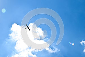 Airplane flying in the blue sky on background of white clouds, rear view. Twin-engine commercial plane during the turn, vacation