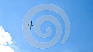 Airplane flying in the blue sky on background of white clouds, rear view. Twin-engine commercial plane during the turn, vacation