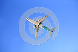 Airplane flying on blue sky. Seen from below