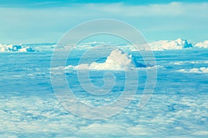 Airplane flying in the blue sky among white clouds