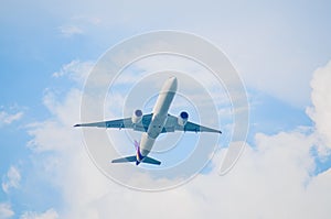 Airplane flying in the blue sky and white clouds, transportation concept