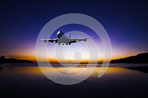 Airplane flying on colorful evening sky over sea at sunset with