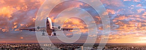 Airplane is flying in colorful sky over the city at sunset