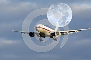 Airplane flying in front of moon