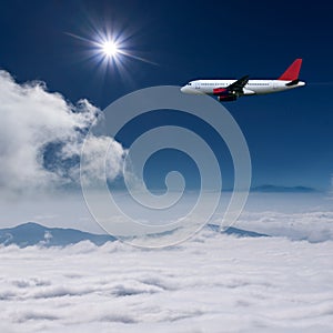 Airplane flying at high altitude above the clouds