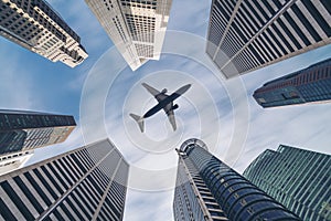 Airplane flying over city business buildings, high-rise skyscrapers