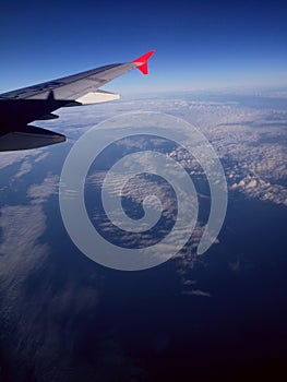 Airplane flying over the Clouds at the Midday - Ocean Blue