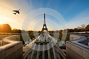 Airplane flying over Eiffel Tower in morning, Paris, France.