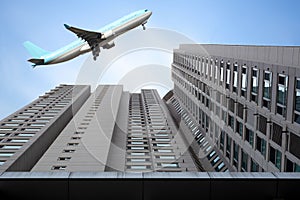 Airplane flying over high buildings sky scrapers