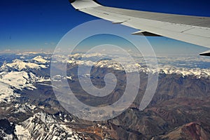 airplane flying over the morning clouds crossing the andes mountain range chile