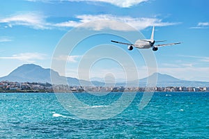 Airplane flying over the sea and beach. Travel concept
