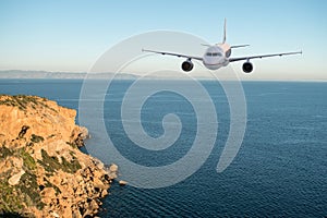 Airplane flying over the sea and mountains.