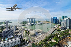 Airplane flying over Singapore city in morning time.