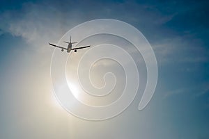 Airplane flying over the sky and sun rays background