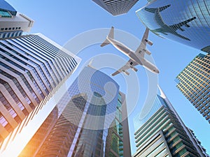 Airplane flying over skyscrapers n city downtown district. Business corporate travel background concept