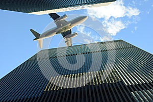 Airplane flying over skyscrappers. Transportation, vacation and travel concept