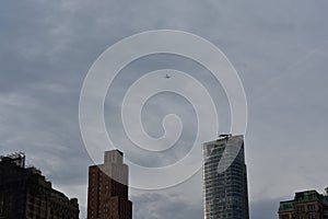 Airplane Flying over Tops of Buildings in Manhattan