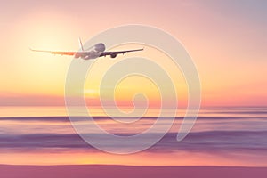 Airplane flying over tropical beach with smooth wave and sunset sky abstract background