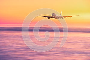 Airplane flying over tropical beach with smooth wave and sunset sky abstract background