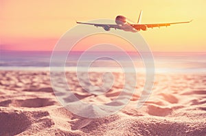Airplane flying over tropical beach with smooth wave and sunset sky abstract background