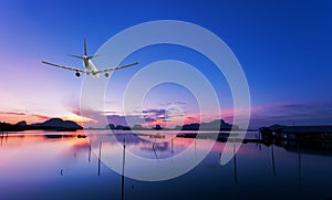 Airplane flying over tropical sea at beautiful sunset or sunrise scenery background