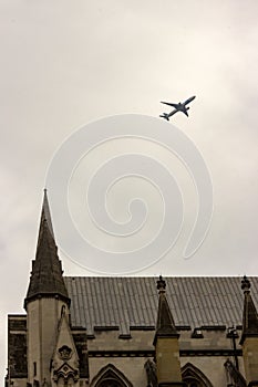 An airplane glides over the rooftop of the British Parliament building in London, England.