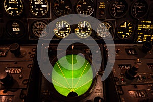 Airplane green glowing radar with aircraft gauges, switches, and